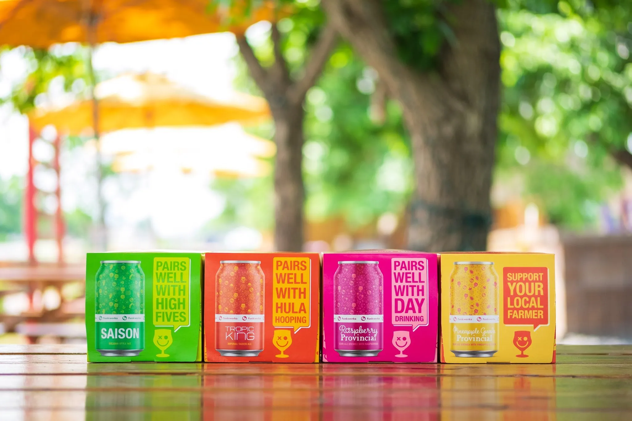 Four Funkwerks 6-packs — Saison, Tropic King, Raspberry Provincial, and White — lined up on a patio table