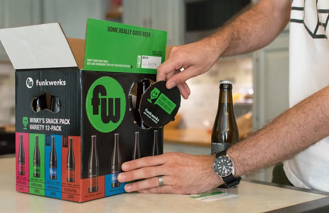 Hands opening a Winky's Snack Pack box and pulling out a bottle