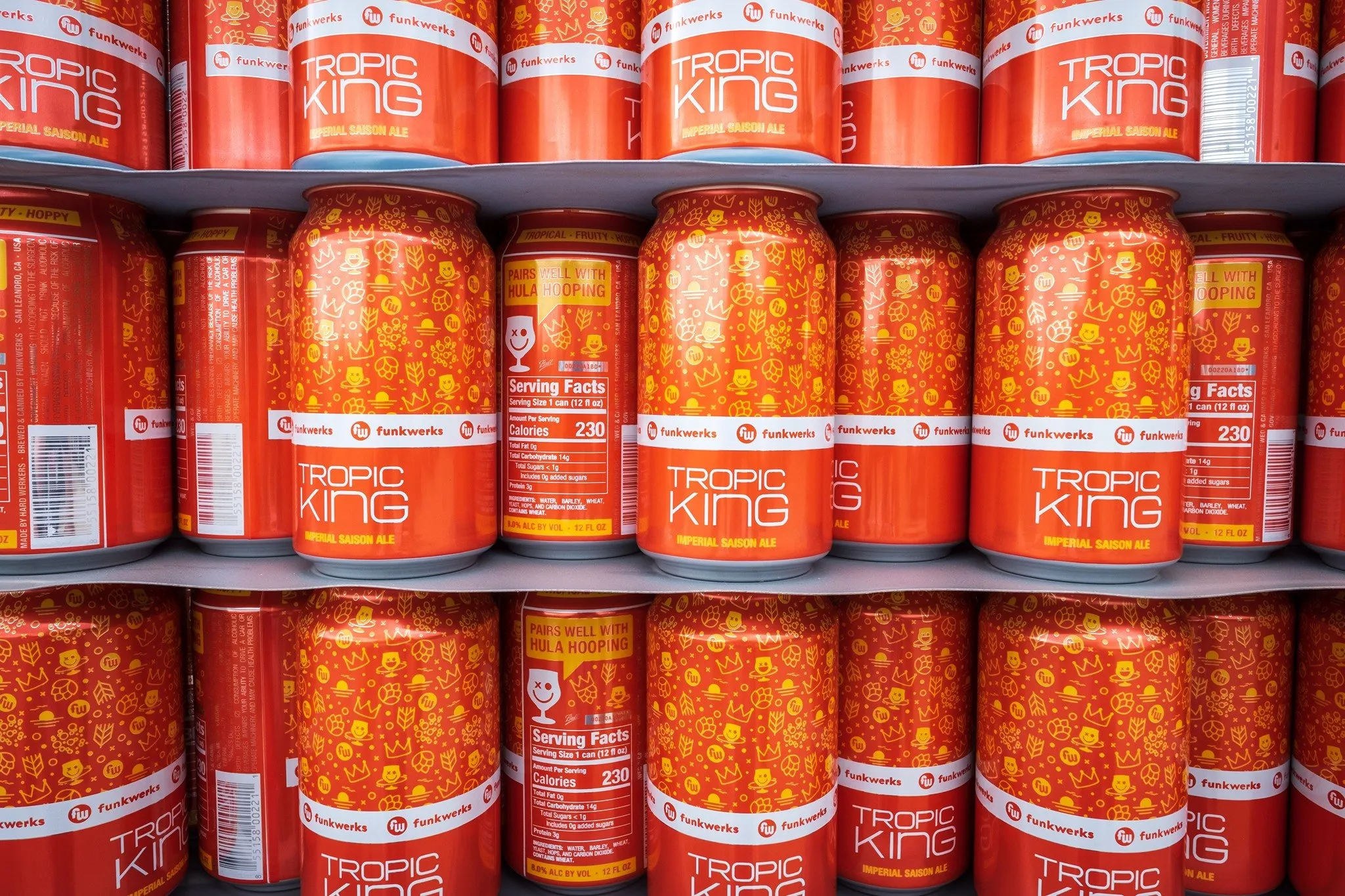 Shelves stacked with orange Tropic King cans