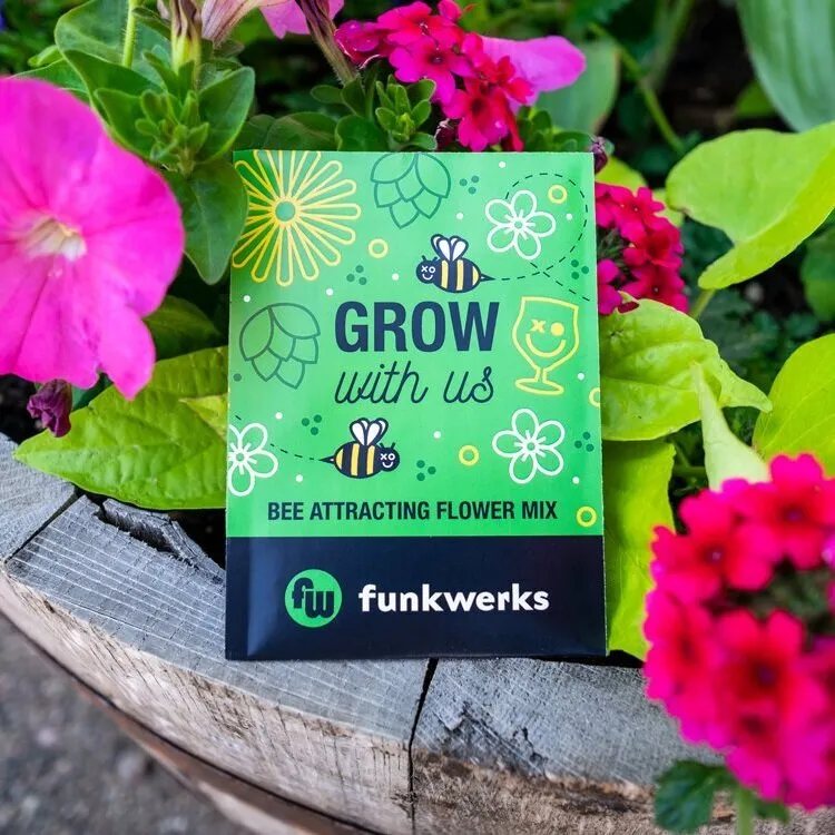 Funkwerks 'Grow With Us' seed packet among pink flowers