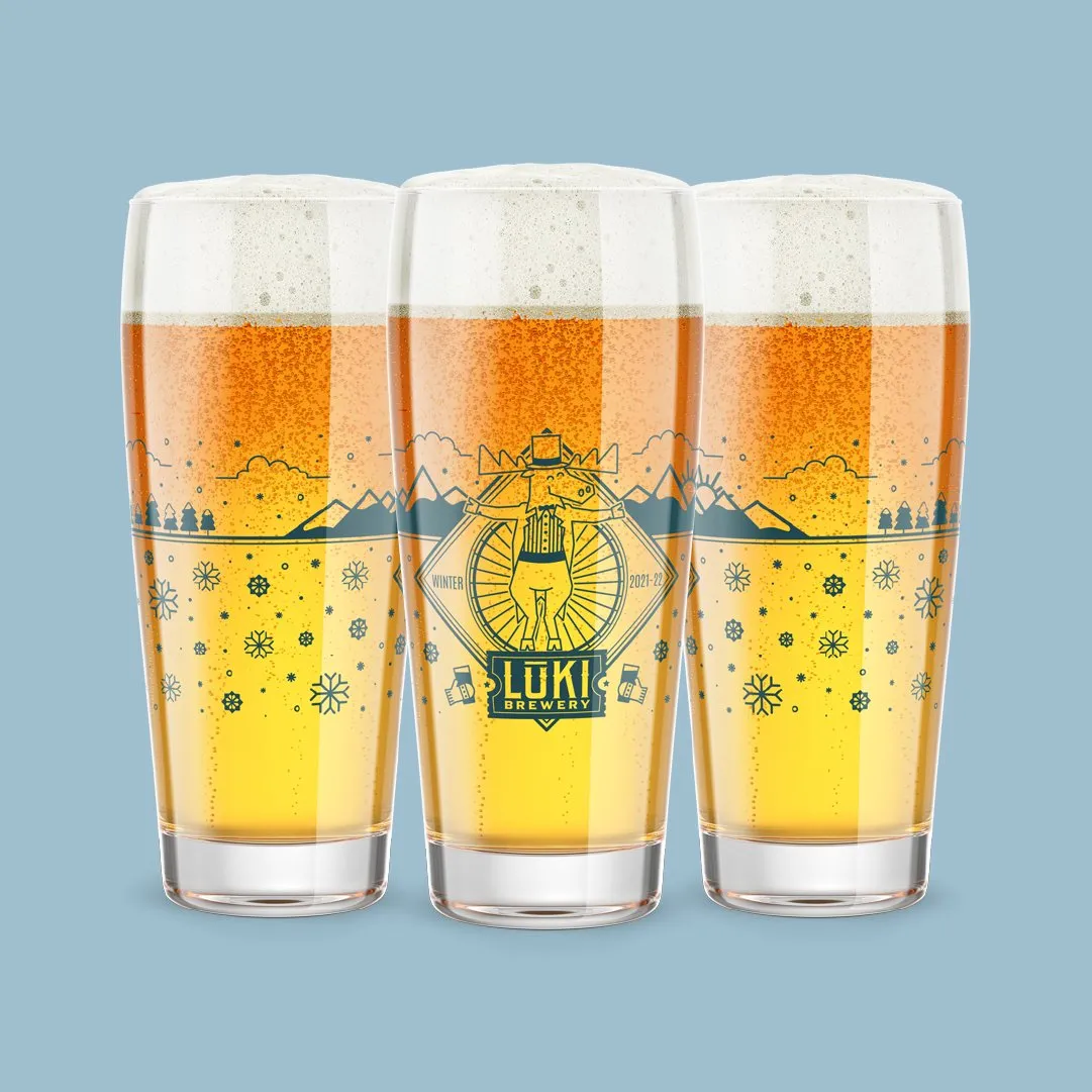 Three Loki pint glasses illustrated with a mountain campfire scene, on blue
