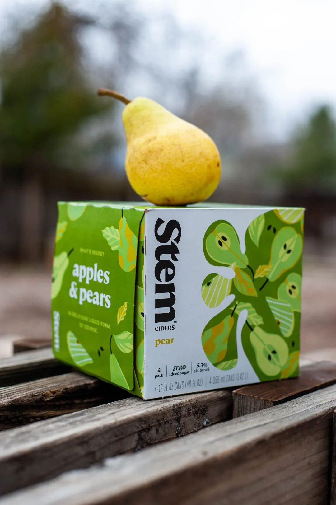 Apples & Pears 6-pack with a pear on top, outdoors