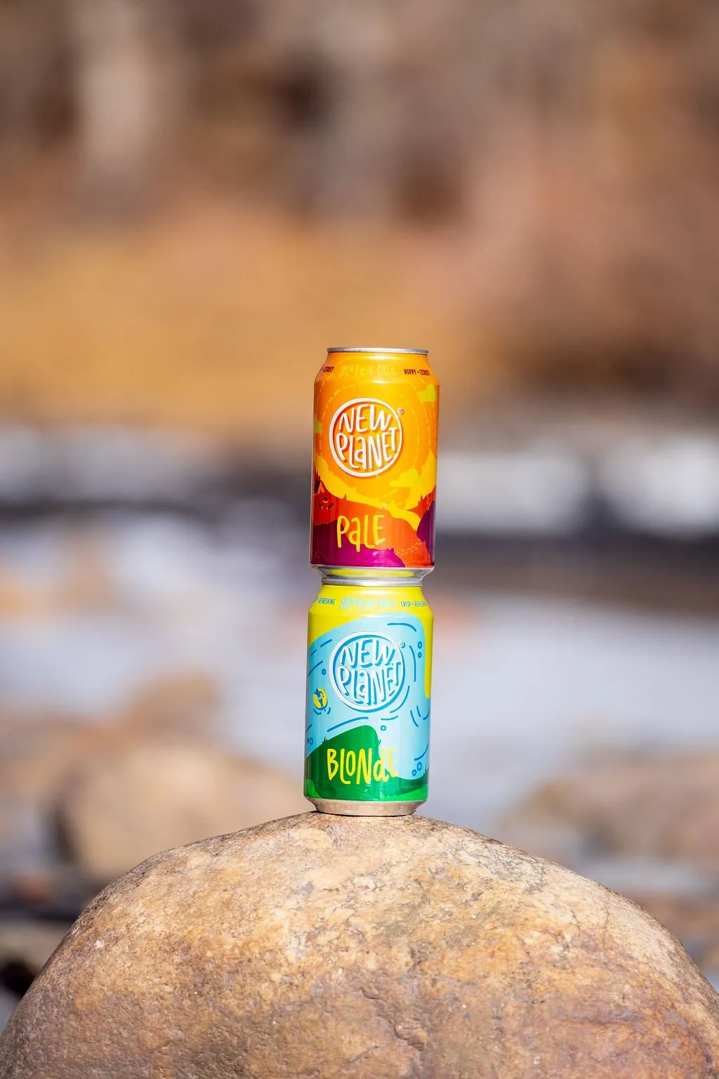 Pale and Blonde cans stacked on a boulder by the river